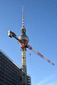 Low angle view of crane against building