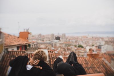 Rear view of people on roof against cityscape