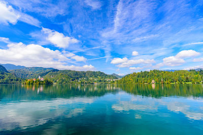 Scenic view of lake by trees against blue sky