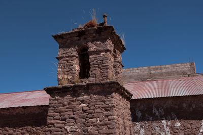 Low angle view of old building against blue sky