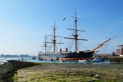 Sailboats moored on sea against clear sky