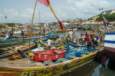 Boats moored at harbor against sky