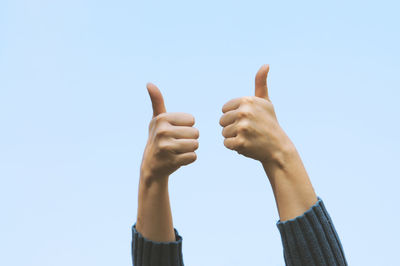 Low angle view of human hand against clear sky