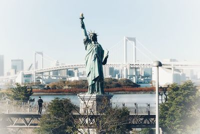 Statue in city against clear sky