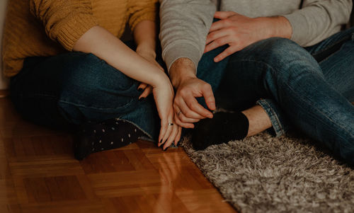 Low section of women sitting on floor at home