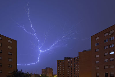 Low angle view of illuminated buildings against sky at night