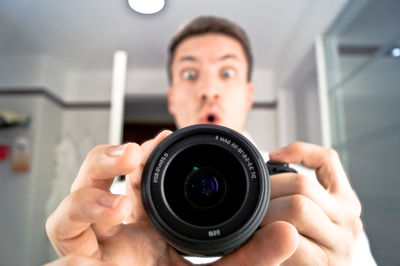 Shocked man holding camera