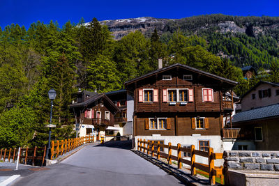 House amidst trees and buildings against sky