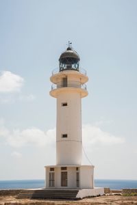 Lighthouse by sea against sky