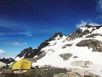 Scenic view of snowcapped mountains against blue sky