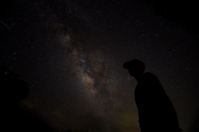 Silhouette man standing against sky at night