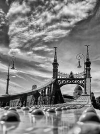 Bridge over river against cloudy sky