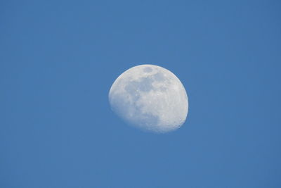 Low angle view of moon against clear blue sky