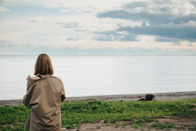 Rear view of woman looking at sea against sky