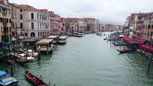 Boats in canal amidst buildings in city