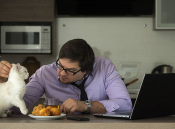 Rear view of man using laptop