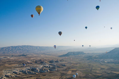 Hot air balloons flying over landscape