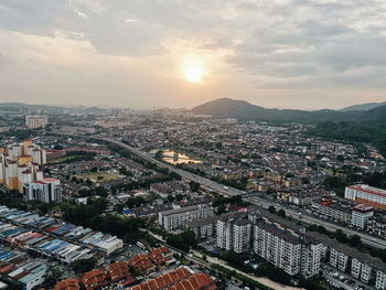 High angle view of city buildings against sky during sunset