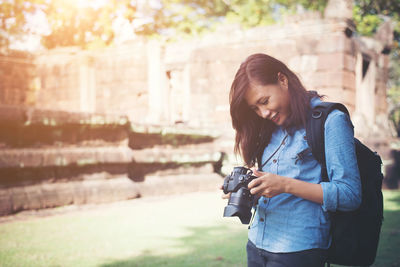 Female tourist using slr camera against old building