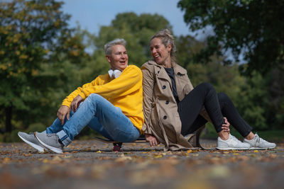 A couple sits romantically on a skateboard