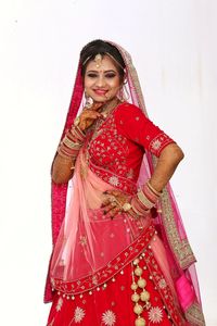 Woman standing against pink background