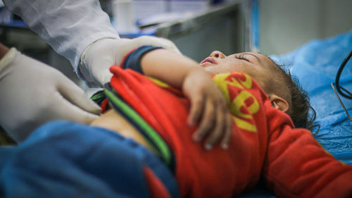 Cropped image of doctor examining baby at hospital