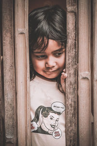 Close-up of girl looking through window