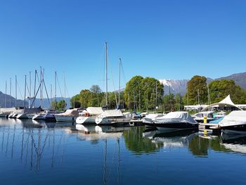 Boats moored at harbor against clear sky