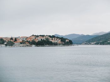 Buildings by sea against sky