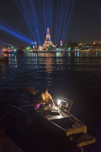 Illuminated bridge over river at night