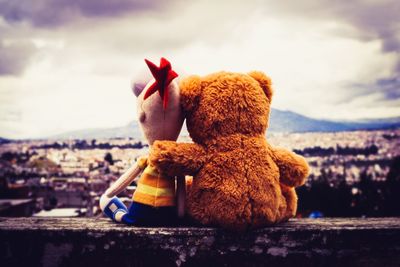 Close-up of stuffed toy against sky in city