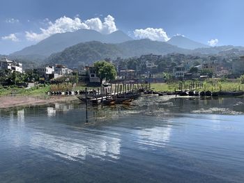 Scenic view of lake by buildings against sky