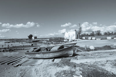 Old boat moored on beach against sky