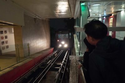 Rear view of man standing at subway station