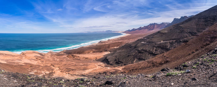 Scenic view of sea and mountains against sky