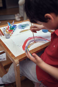 Children playing in an inner courtyard and painting with water paints