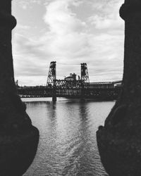 Bridge over river against sky in city