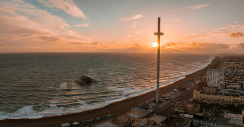 Magical sunset aerial view of british airways i360 viewing tower pod with tourists in brighton