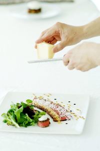 Close-up of hand grating cheese