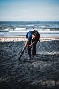 Full length of woman on beach against sky