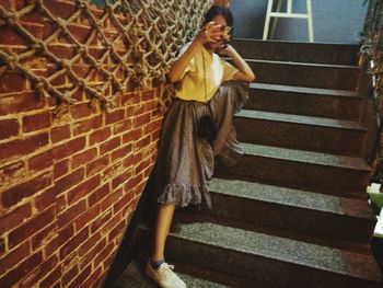 Low angle view of young woman on steps