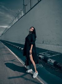 Portrait of young woman walking on road