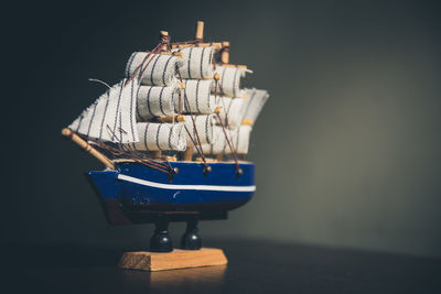 Close-up of toy boat on table against wall