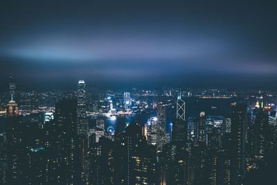 Illuminated cityscape against sky at night