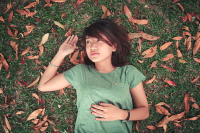 High angle view of young woman lying on field during autumn