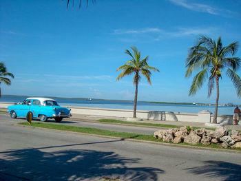 Road by sea against blue sky