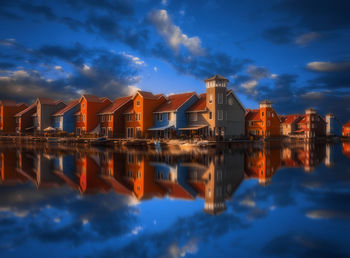 Reflection of buildings in lake against sky