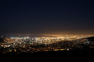 Illuminated cityscape against sky at night