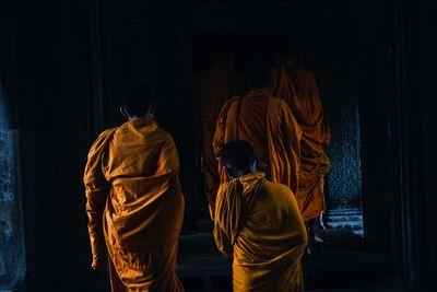 Rear view of monks walking in temple