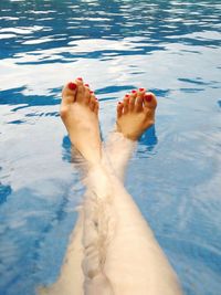 Low section of woman relaxing in swimming pool